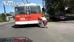 Old Woman Pushes A Broken Trolley Bus