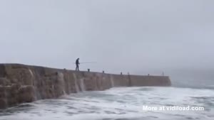 Fisherman Blown Away By Big Wave