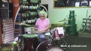 Elderly Woman Playing The Drums In Store