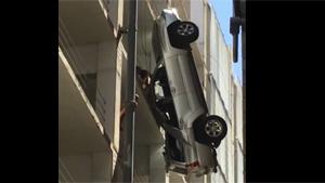 Man Climbing From Dangling Car